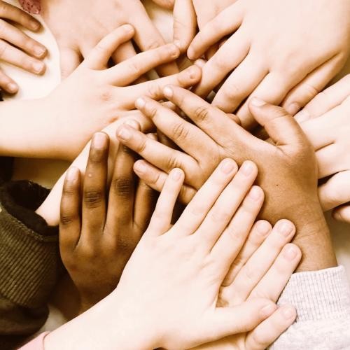 Mehrere Kinderhände liegen übereinander