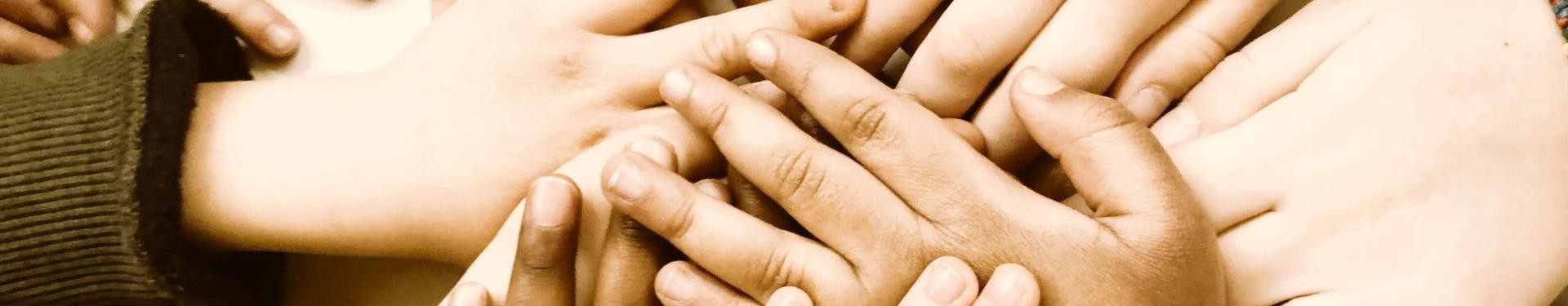Viele Kinderhände liegen übereinander