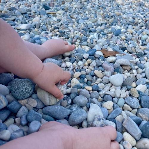 Kinderhand greift nach einem Stein